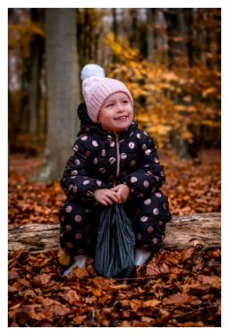 grandaughter playing in the woods in autumn